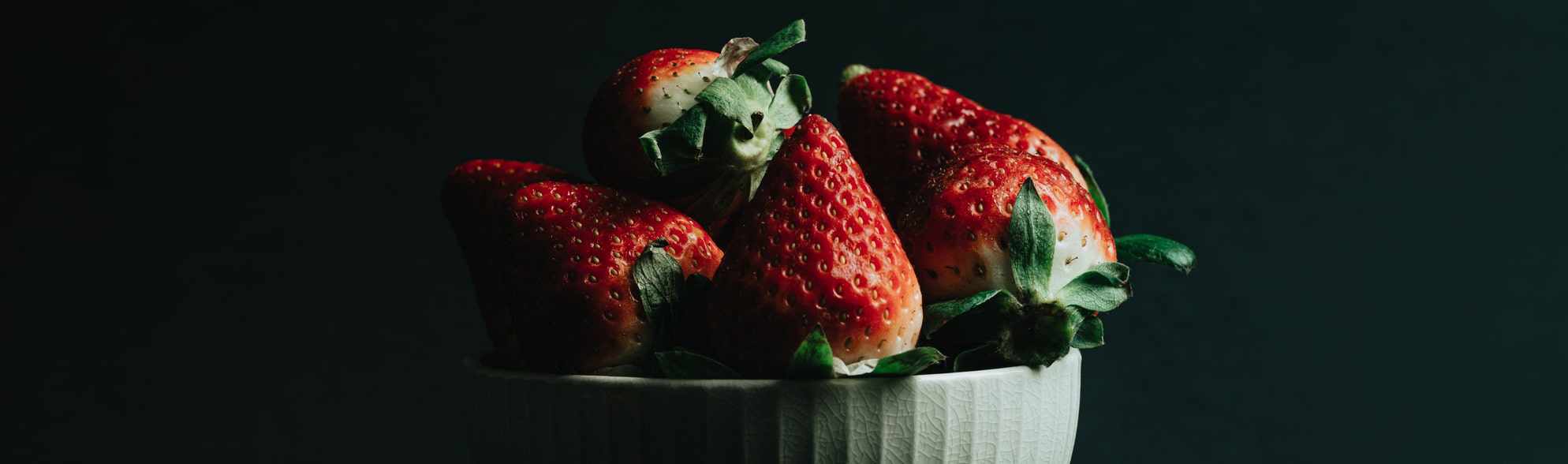 ripe red strawberries in a white bowl